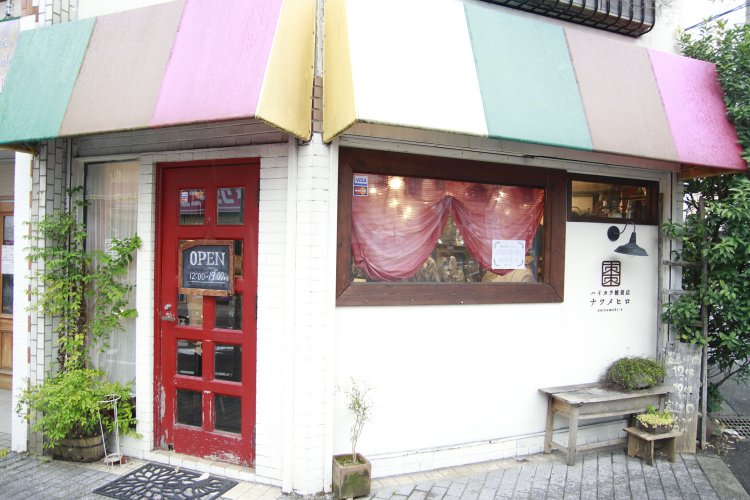 元は古い洋品店だった店舗。特注したカラフルなファサードテントと赤い扉が目印だ。