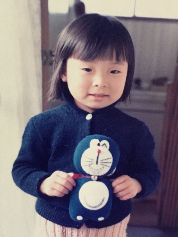 大叔母手作りのドラえもんぬいぐるみと写る幼少時の筆者。割とよくできていると思う