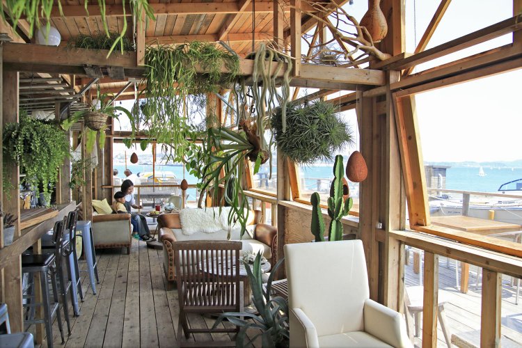 熱帯植物、ソファ、木製電線リールのテーブルを配し、居心地最高！