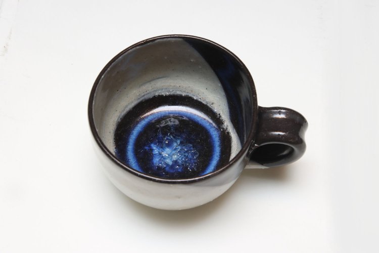 近藤九心さんのマグカップ2100円。新潟に焼き窯を持つ作家が手がける。中心に広がるブルーのガラス質の釉薬（ゆうやく）が特徴的で、まるで宇宙みたい！