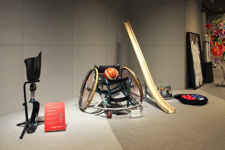 パラサポ入り口に展示された用具の数々。左から義足、バスケットボール用車いす、投球できない選手がボールを転がすボッチャのランプ。