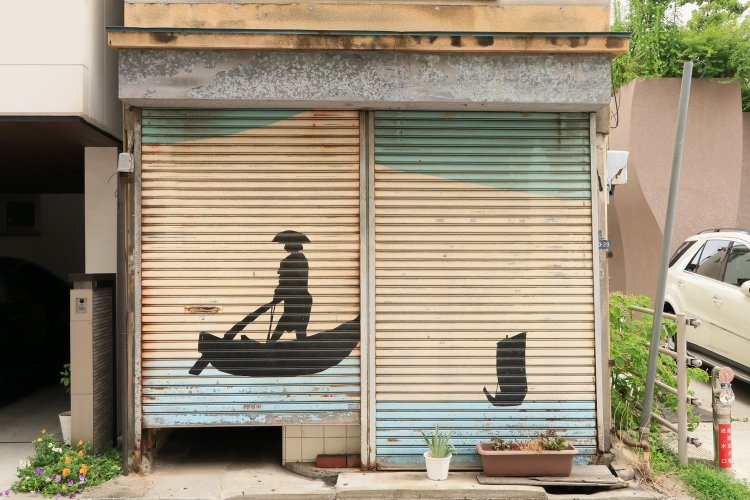 江戸湾で櫂を漕ぐ姿と帆船。