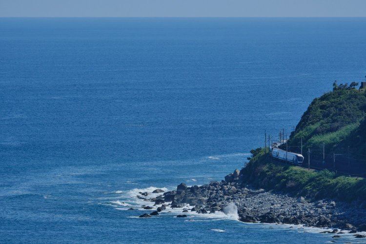 片瀬白田の沿岸を曲がる。車両は揺れを減衰させる装置を備え、カーブでも揺れにくい。