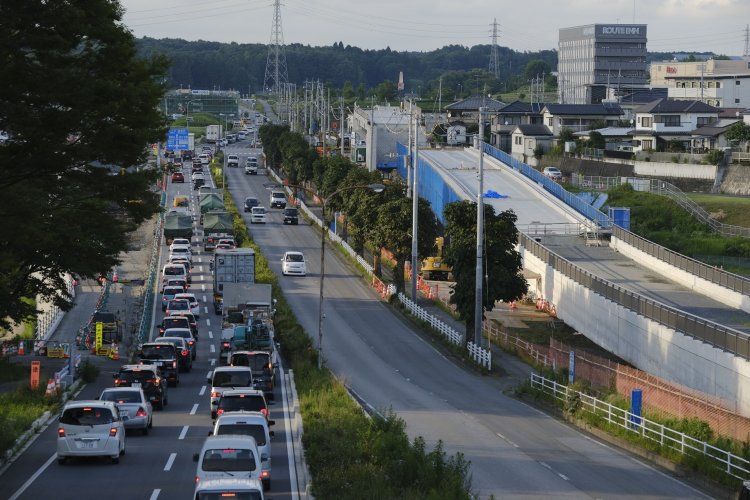 野高谷（のごや）町交差点付近にLRT専用の高架を建設中。左側は夕方の渋滞中。