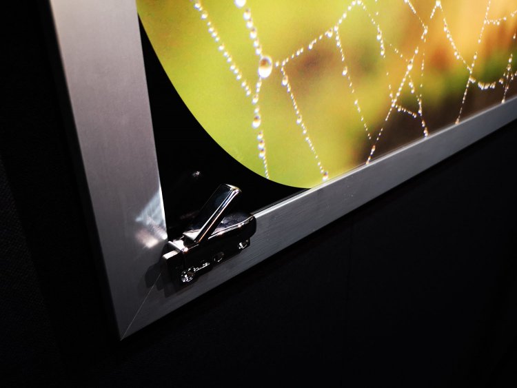 車窓に見立てられた展示作品。額には鉄道の窓に取り付けられたロックが仕込まれている。さらに窓の合間には衣文かけまで配置。