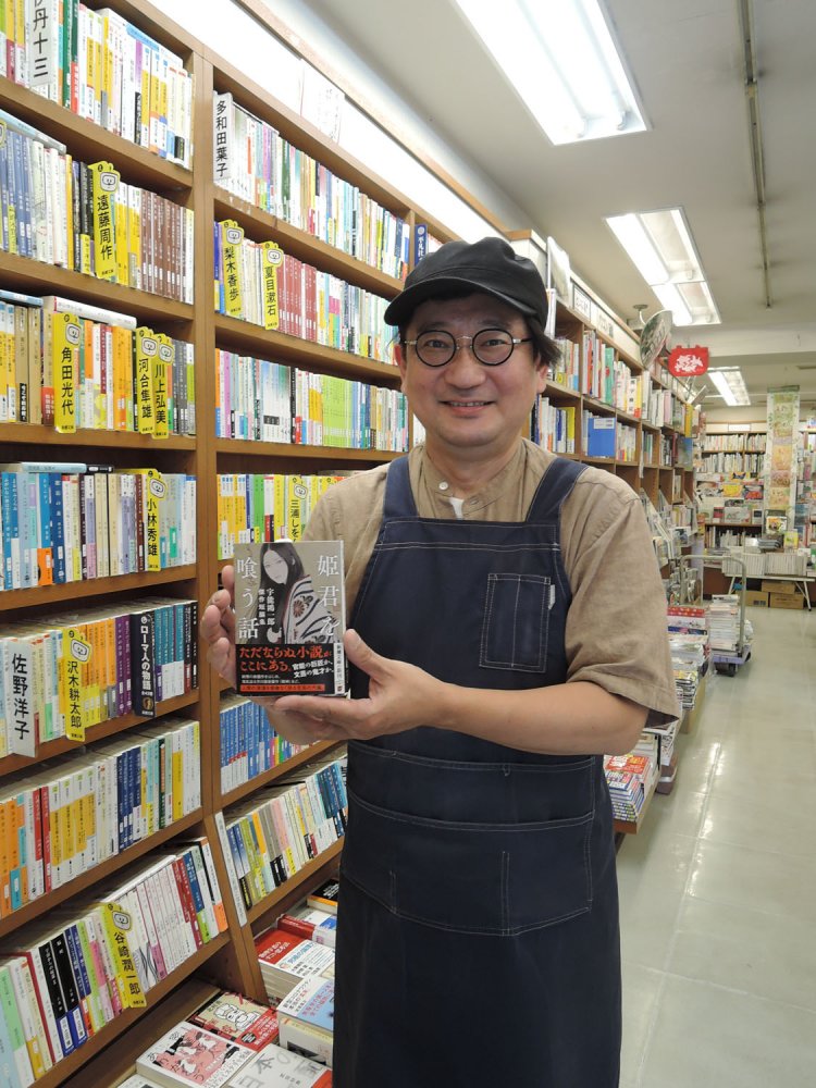 オススメの『姫君を喰う話　宇野鴻一郎傑作短編集』を手にする笈入建志店長。