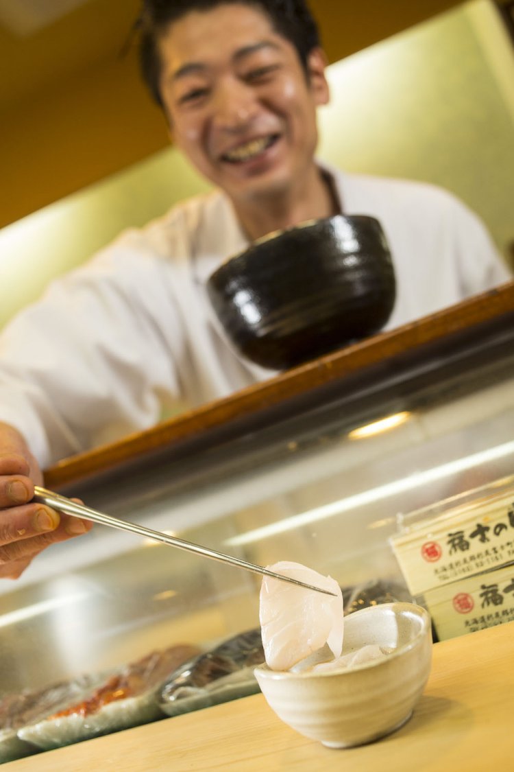 クエのしゃぶしゃぶをポン酢の器に盛る森田さん。
