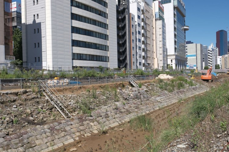 発掘調査中の高輪築堤を海側から。この石垣と築堤部がそっくりそのまま地中から現れた。中心部分の石垣が膨らんでいるのは信号機跡。海側の石垣の角度は30°であった。