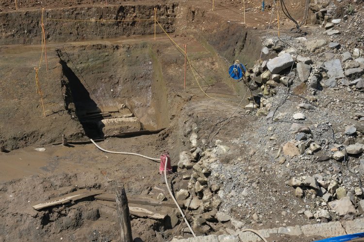 カットした部分を拡大。さらに狭くカットされた部分とその周りがカマボコ状の曲線となっている。その部分が「築堤基盤」となる。右の雑石は裏込石。