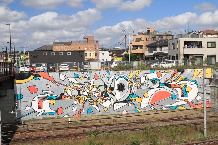 線路沿いの壁面に描かれた『letter〝酔狂〞-生命の音-』。世界的なグラフィティアーティストSUIKO氏の作品。