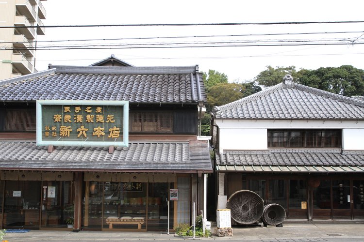 右が明暦元年（1655）創業の『田中酒造店』。店の前に杉樽のオブジェが飾られる。左が明治元年（1868）創業の『新六本店』。