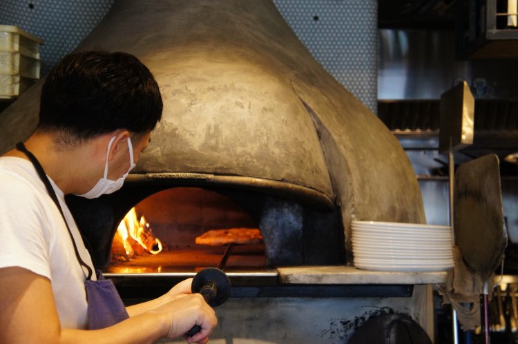 鍛えた腕をもつ職人が丁寧に焼き上げるピザ。温度管理が何より重要だという。