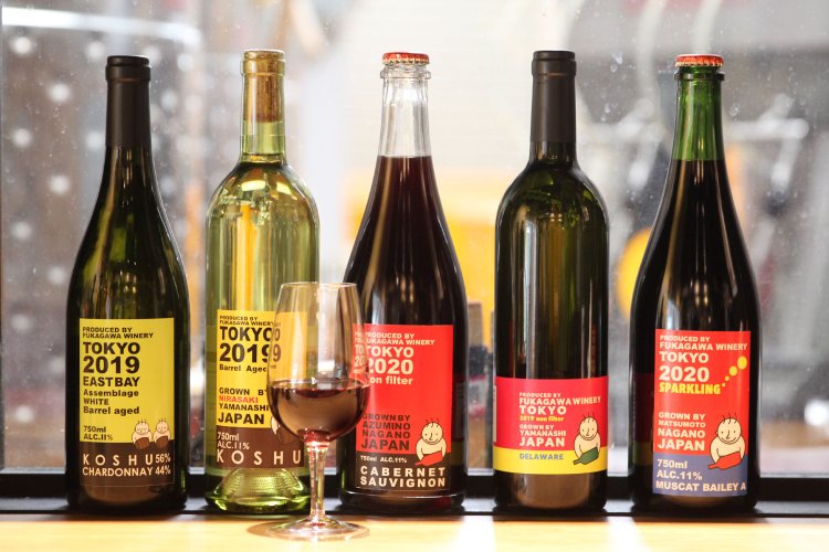 『深川ワイナリー東京』の醸造所のタンクを望むカウンター席。酸化防止剤無添加の長野カベルネソーヴィニョン3520円（中央）など。