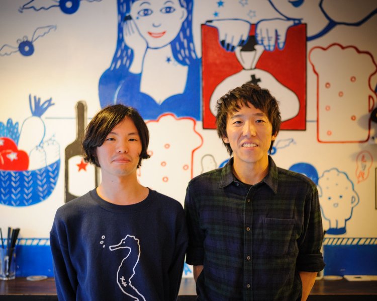 辻さん（左）はバンドcinema staff、會田さんはcore of bellsで活動。後ろの壁画は椎木彩子さん作。