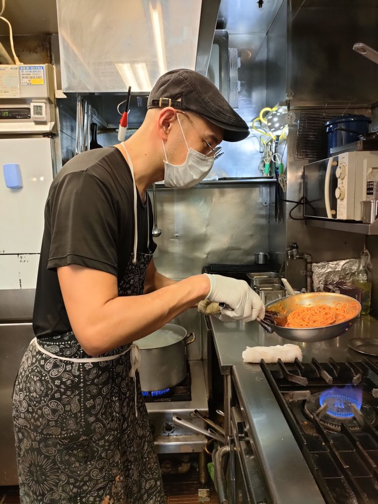 コックの熊谷達人さん。手際よく鍋を振るう。