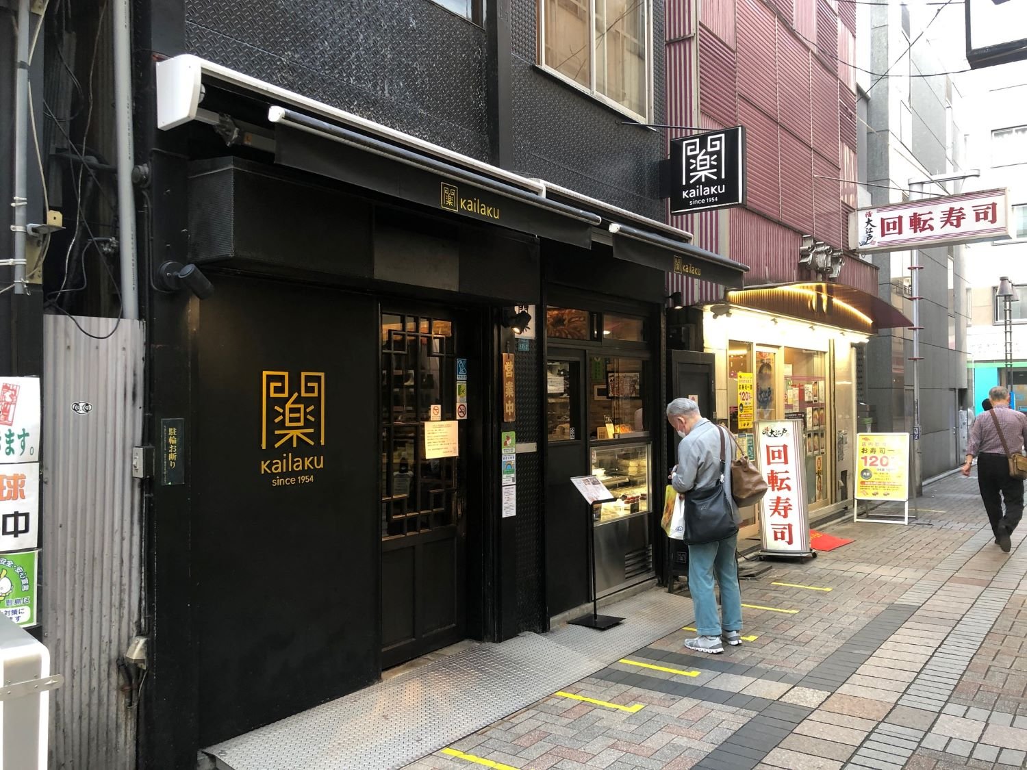 町中華らしからぬ、ダークな色合いがかっこいい。並ぶ場所を示す足元のマークは行列のできる店の証。