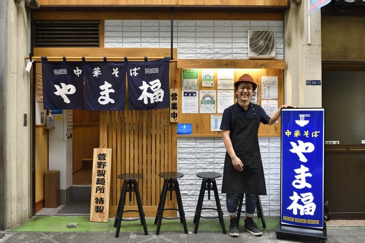 青い暖簾と看板が目印。