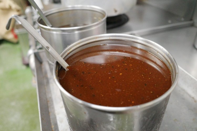 味の決め手は手づくりのタレ。使うときは底からお玉で掻き出すようにすくう。タレのレシピはごく一部の人間しか知らない、まさに秘伝。