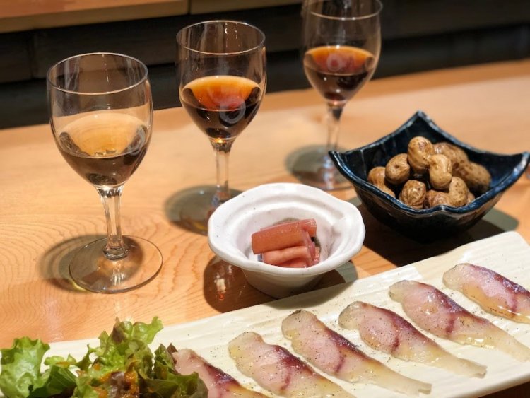 シェリー酒おまかせ飲み比べセット（奥の3つのグラス）と魚の生ハム600円（手前）。