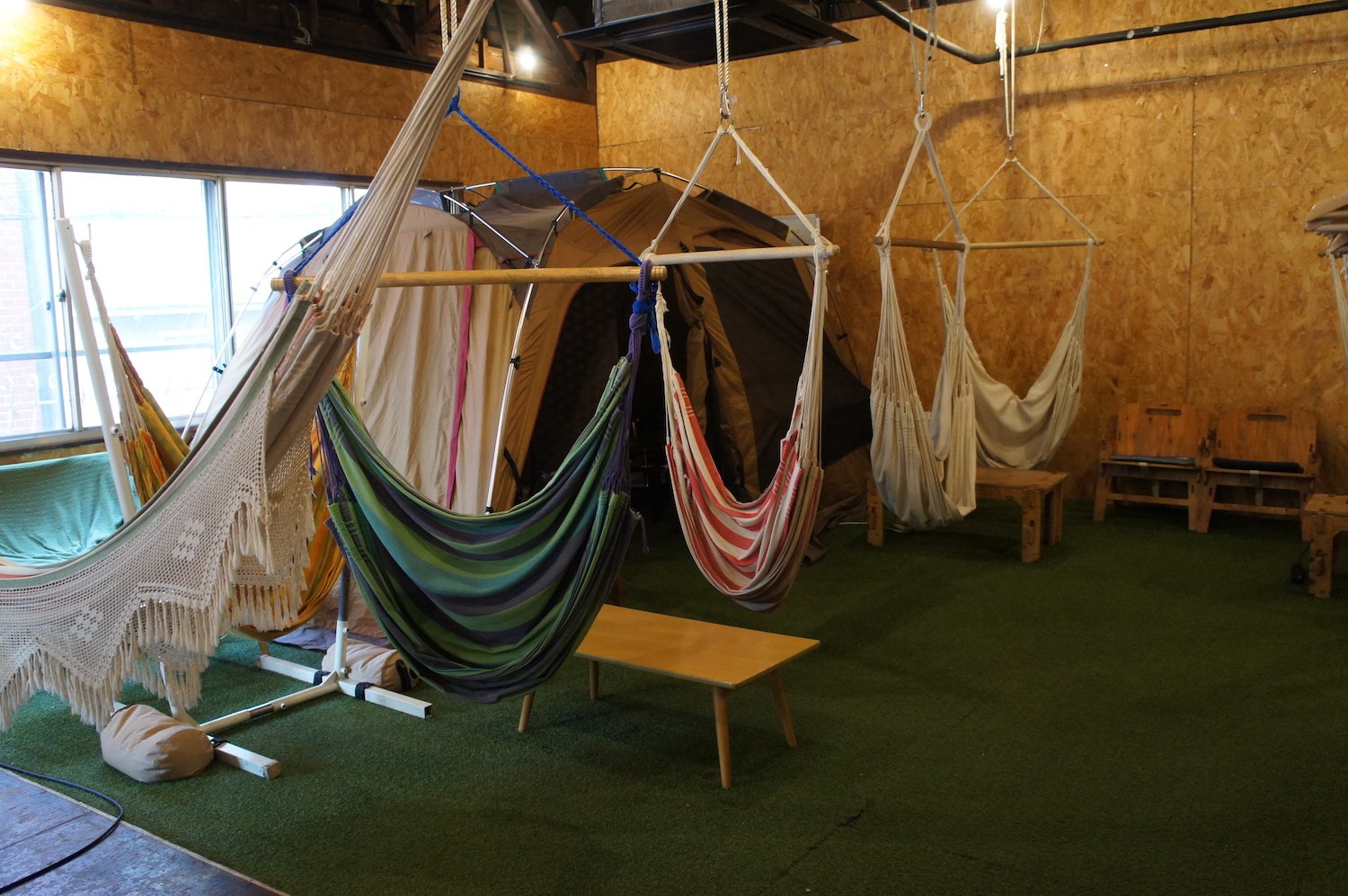 吊り下げタイプ、ベッドタイプと様々なハンモックがある。大型テント内にはソファも完備。