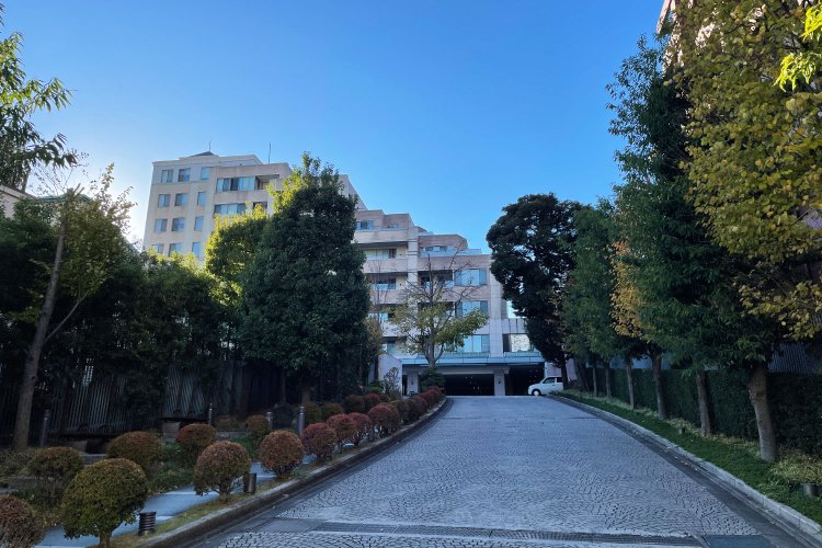 「特徴は道路からエントランスまで続く優雅なアプローチ。石タイルを欧風に敷き詰めた通路の意匠を含め、まるで一流ホテルのよう」と石川さん。左半分は港区立伊皿子坂緑地として一般にも開放されている。