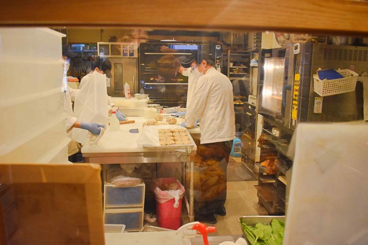 お店の奥にある厨房では、スタッフたちが忙しそうにパンを製造している。