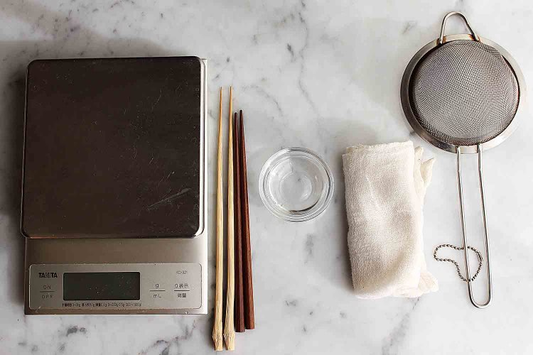 12月の生菓子の1つ「サンタクロース」に使う道具。左から「はかり」、「先の細い箸」、「丸みのある箸」、「水10ml」、「濡れ布巾」、「茶こし（または「ふるい」）」。