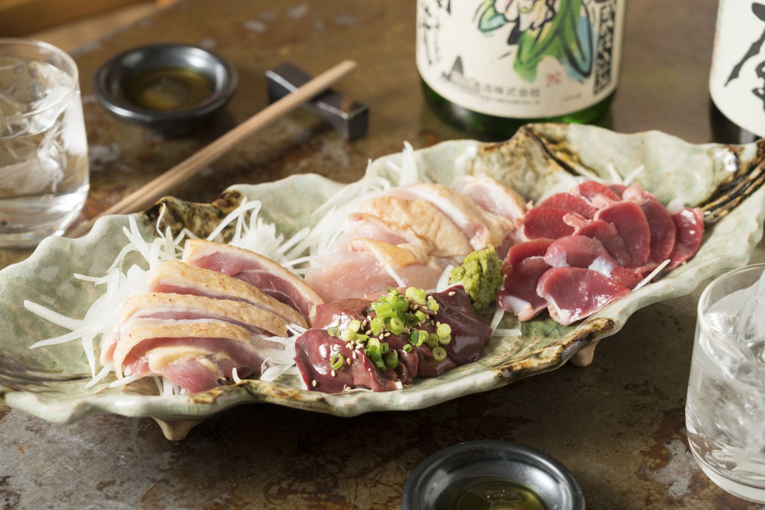 鶏刺し盛り合わせ1580円。鹿児島の鶏肉店から直で仕入れた地鶏と200種類を超える全国の焼酎580円〜が名物。