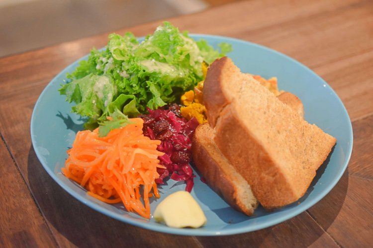 4種のデリプレート990円。グリーンサラダに、キャロットラペ、紫キャベツのマリネ、かぼちゃサラダ、ひよこ豆のフムスの４種のデリ、全粒粉の食パンが一皿に。