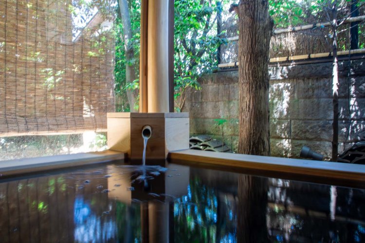 プライベートな入浴を楽しめる離れの湯「燈」は半露天の檜風呂。