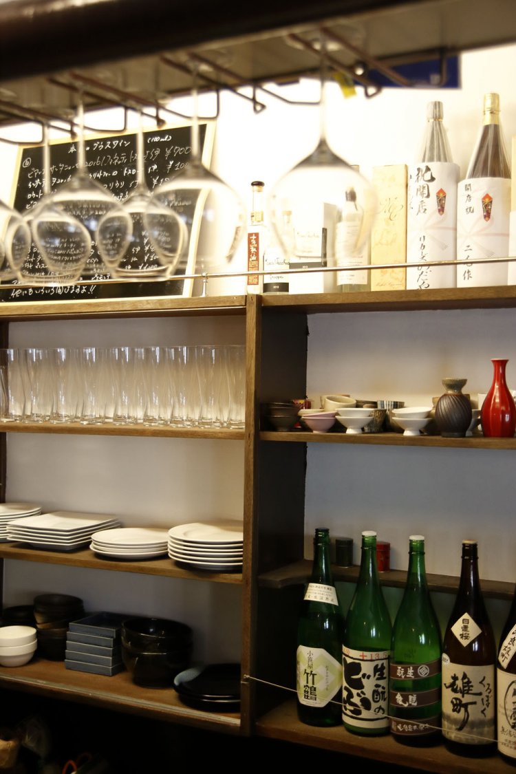 カウンターにはワイングラスと一升瓶が並ぶ。