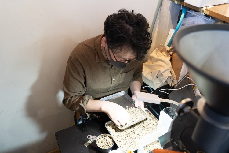 注意深く傷んだコーヒー豆を取り除いている。