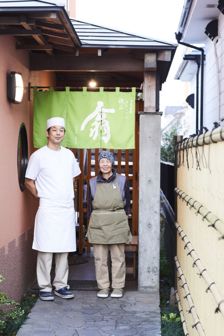 店主の小川誠二さんと、接客担当のお母さんのキサ子さん。お母さんが採ってきた山菜の塩漬けやおひたしなどの小鉢も名物の一つ。