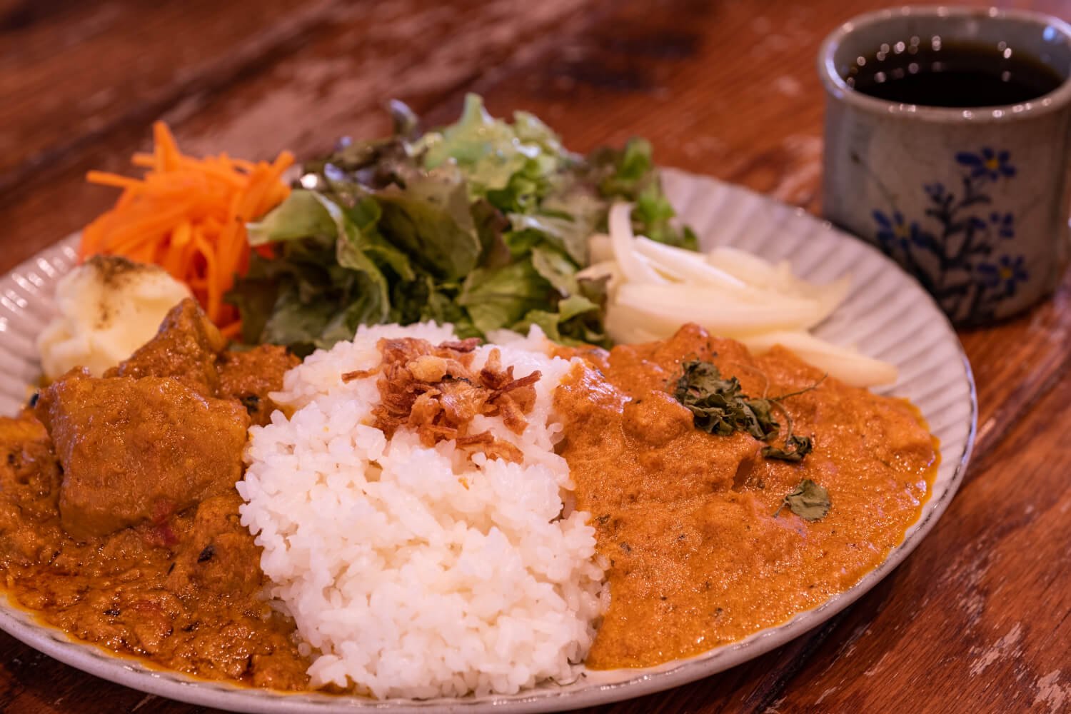 バターチキンとポークビンダルーの2種盛りカレー 1200円(セットのドリンクは100円引き)。