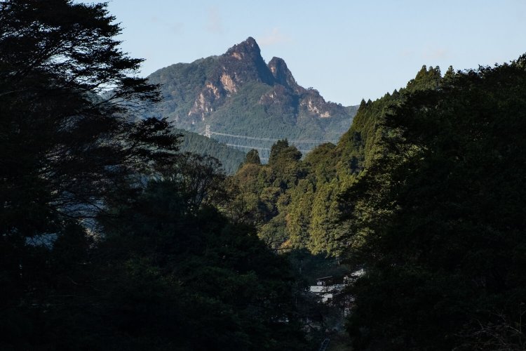 南牧村中心部から三段の滝上部にそびえる大岩（左）と碧（みどり）岩を見通す。