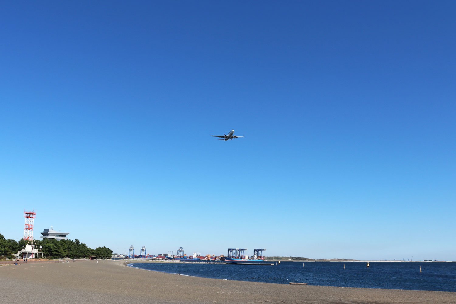 海岸のすぐ上を飛んでいく飛行機。