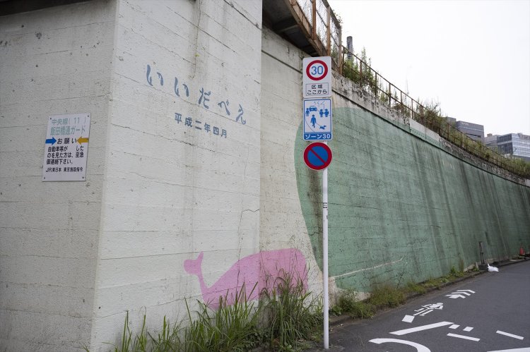 汚れた高架線の塀を美化すべく、美大生の手で描かれた「いいだべえ」。クジラである理由は謎。