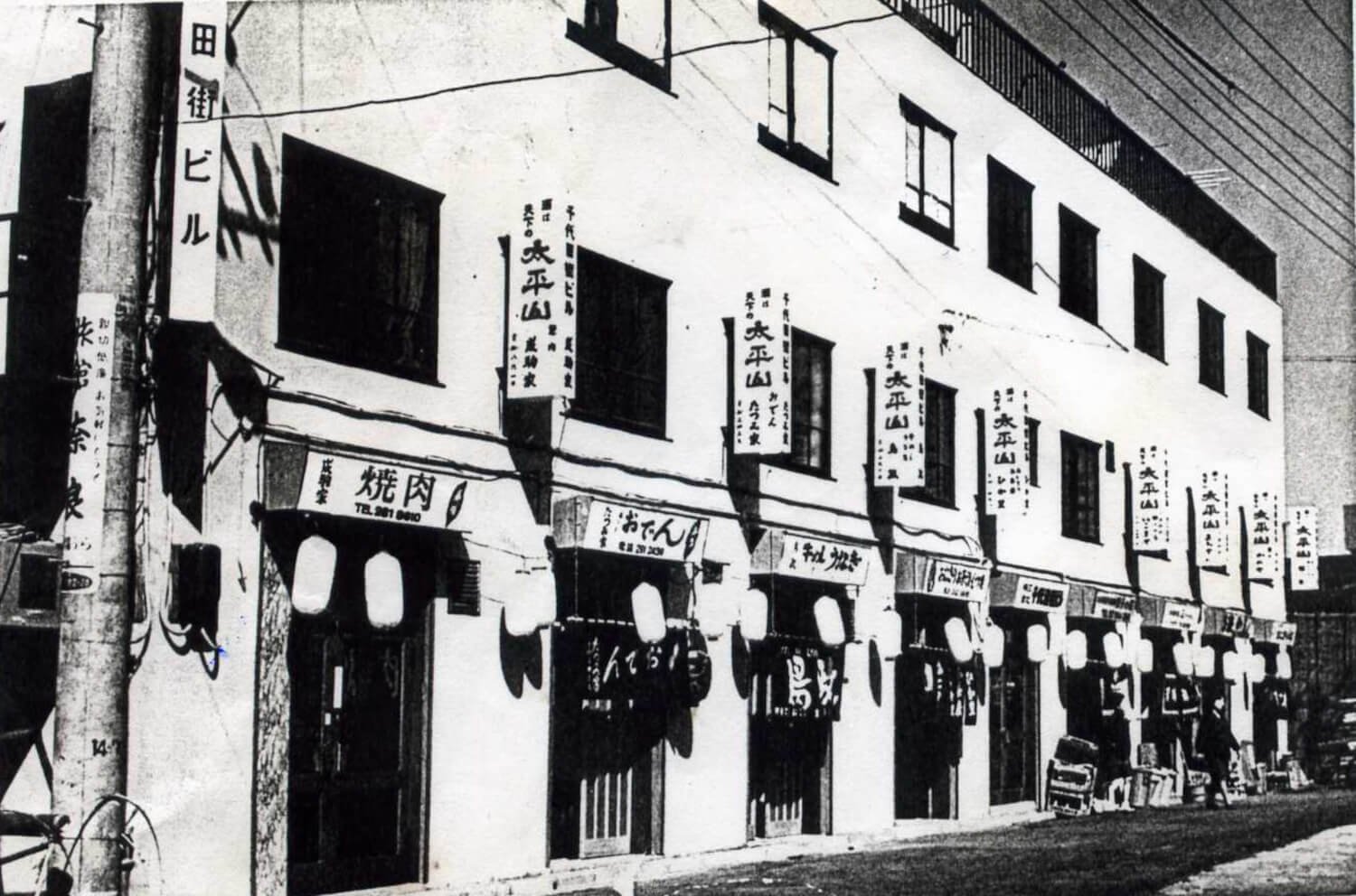 昭和40年、完成したビル。看板に秋田の地酒「太平山」の名が見える。（写真提供：『鳥政』）。