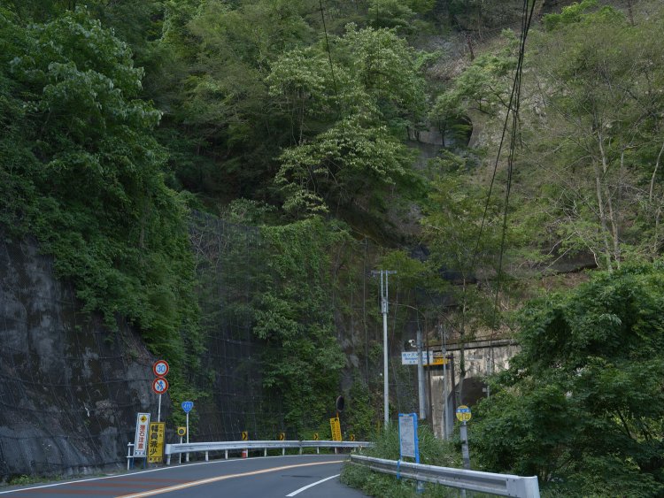 桃ヶ沢バス停からみた第一桃ヶ沢トンネルと桃ヶ沢橋梁。写真上のほうにトンネルが口を開けている。