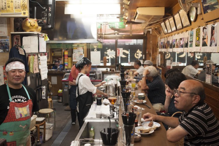 お客さん背後の壁には店主宰の写真クラブの作品が。地元の常連客が集まり、そこかしこで自然に会話が始まる。