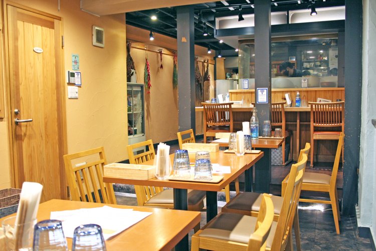 奥のオープンキッチンに沿ってカウンター席が並ぶ。