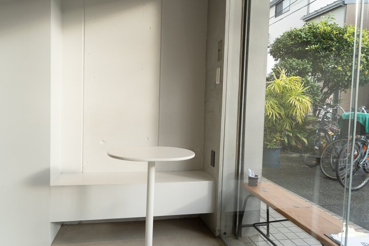 道路に面していて全てガラス張り。白いテーブルが映える。