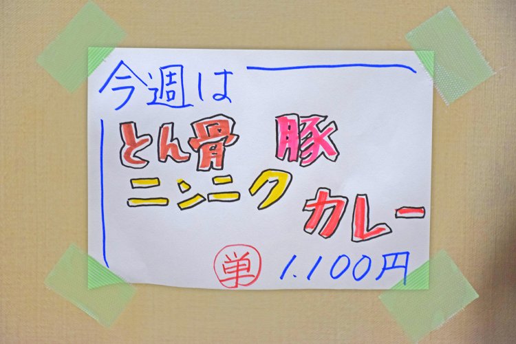 店内に貼られた週替わりカレーの手書きメニュー。売り切れの場合は、エレベーターの4回ボタンの下に貼り紙がしてある。店主の誠実さが伝わる。