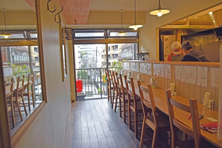 大きな窓がある明るい店内。カウンター前には、それぞれのカレーの説明が丁寧に書かれた手書きのメニューが貼られている。