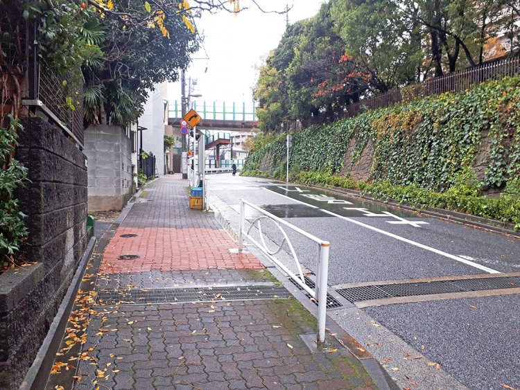 跨線橋が見えたらその手前の路地を曲がる。歩道の一部がレンガ色になっているところが目印。