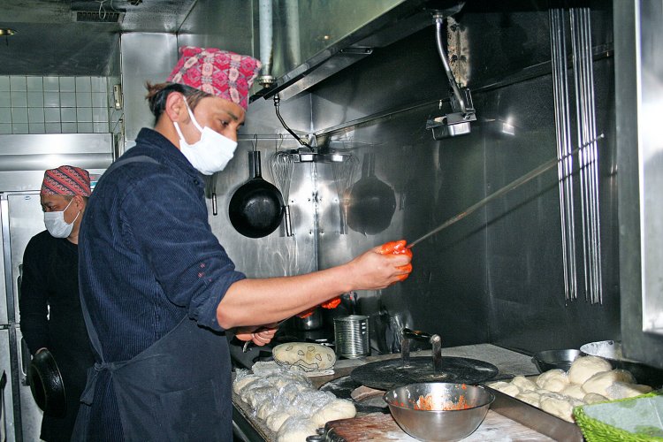 長い串にチキンを差しタンドール窯で焼く。厨房のスタッフもタカリ族の出身。