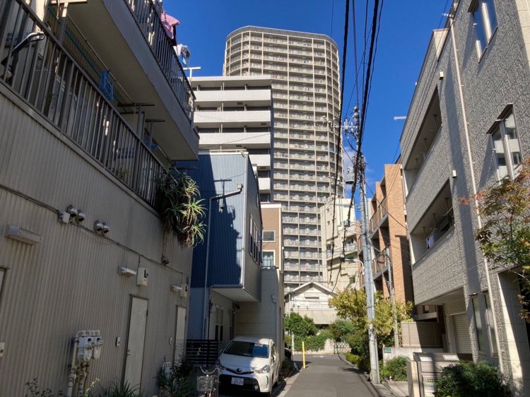 商業地域の路地からみた風景。商業施設も住居も入り混じる。