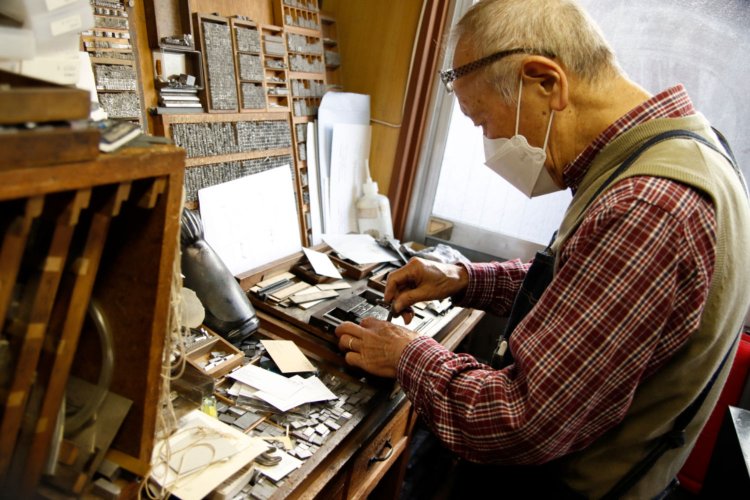 植字台で活字を版にする会長（佐々木さんの父）。
