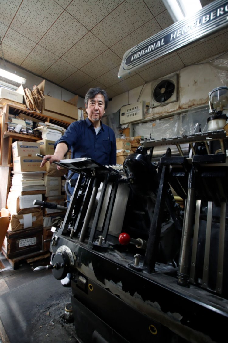 半世紀以上現役というドイツ製のハイデルベルク印刷機と髙岡さん。