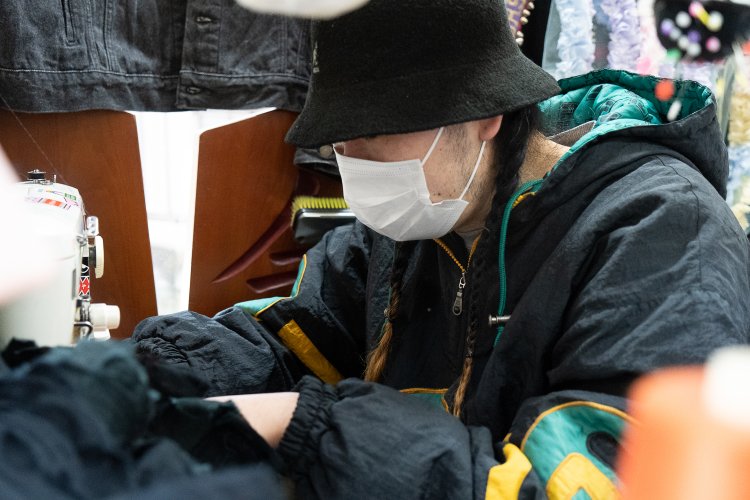 カウンターの中でミシンがけに勤しむ店主、後藤慶光さん。